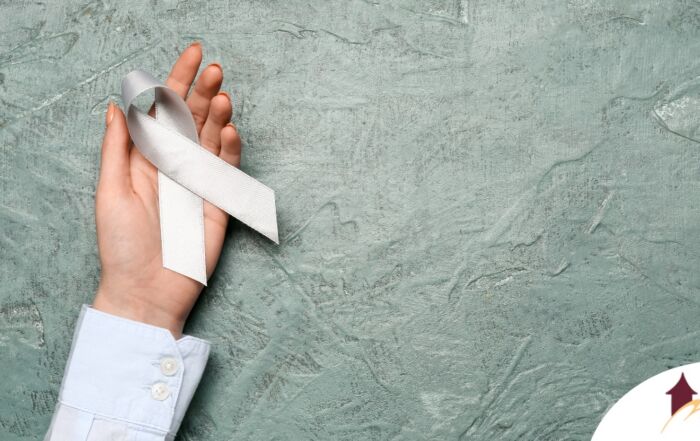 A woman holds a silver ribbon, representing Parkinson’s Awareness Month.
