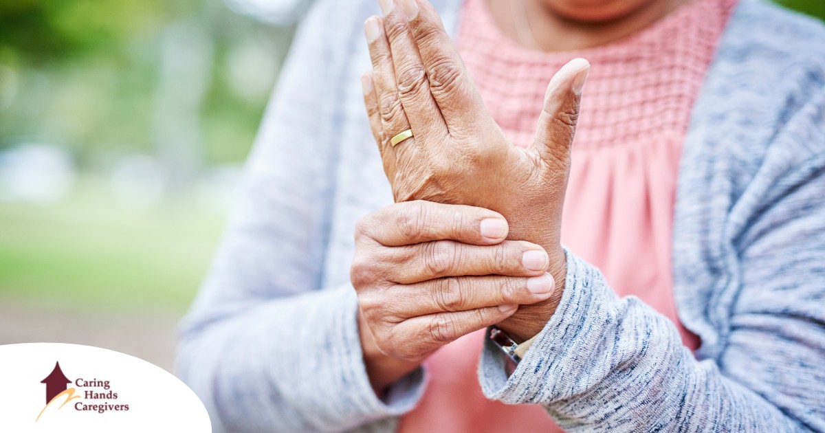 A senior woman holds her hand in pain, representing arthritis and what Arthritis Awareness Month can help with.