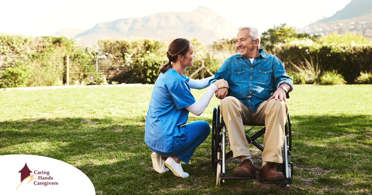 Caregivers like this one talking to a smiling senior patiently and compassionately help clients and help them with aging in place while dealing with different conditions.