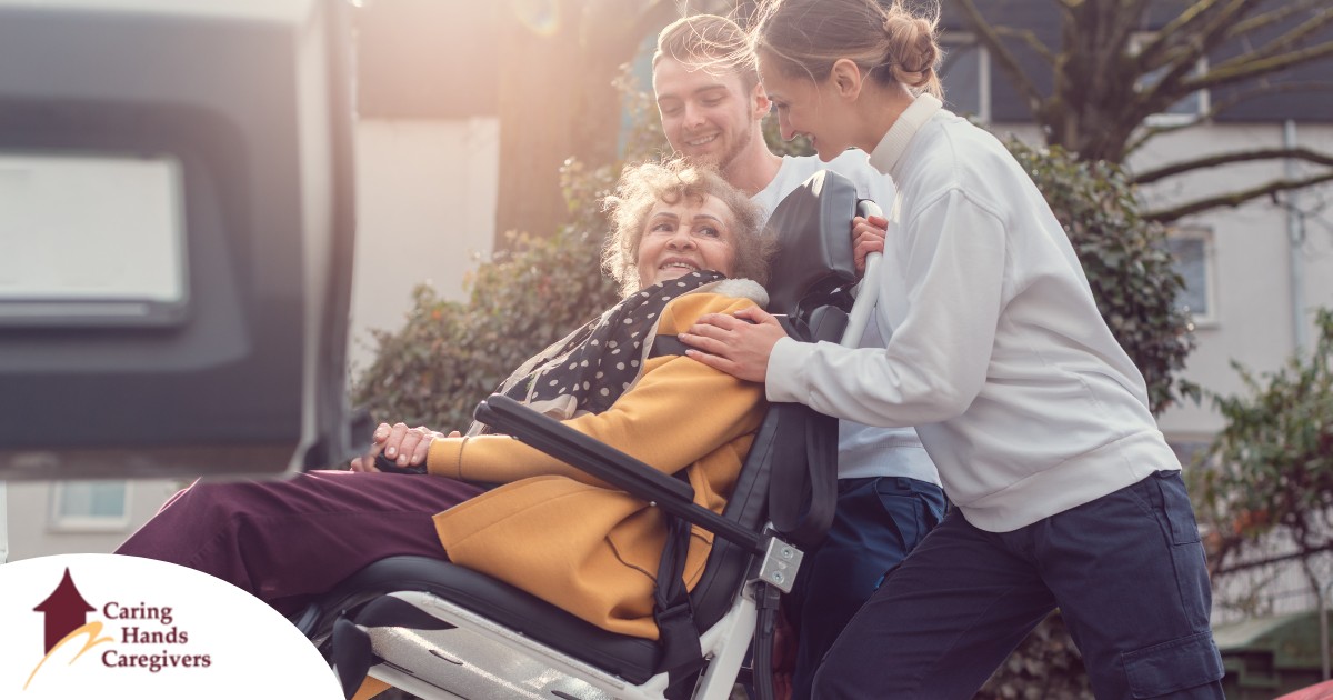 2 caregivers help an older adult get into a vehicle using a ramp, showing how equipment is valuable to professional caregivers when helping older adults.