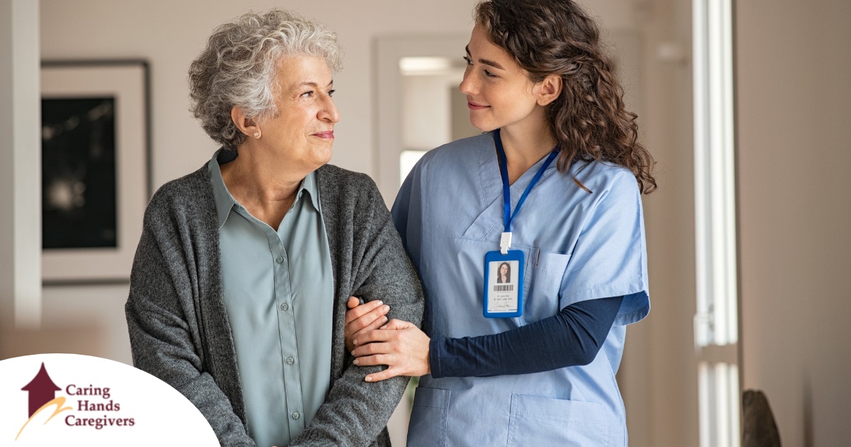 A caregiver and client smile at each other as the caregiver helps the client, representing emotional intelligence in caregiving.