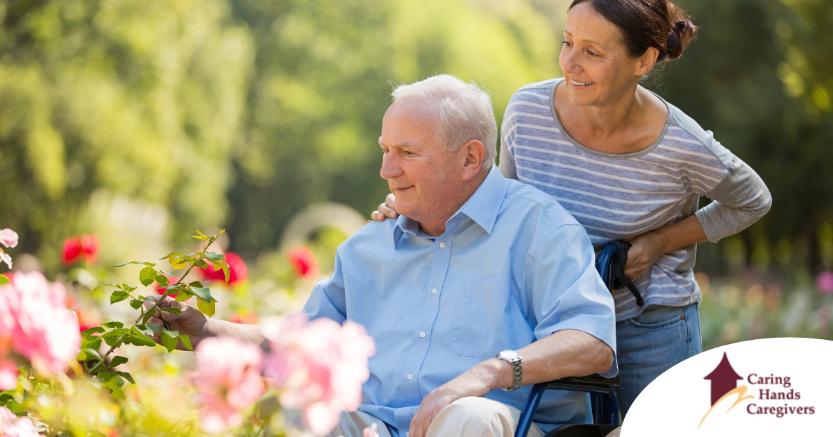 A caregiver takes a senior outside to visit a garden, highlighting one idea for senior activities.