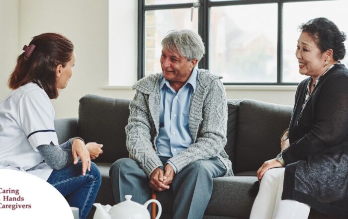 A caregiver talks with an elderly couple representing the kind of communication that professional caregivers need to have to anticipate client needs.