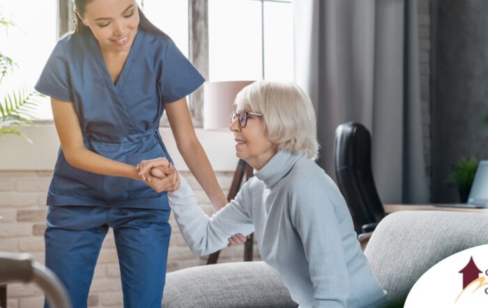 A caregiver demonstrates her caregiver skills by helping an older adult get up.