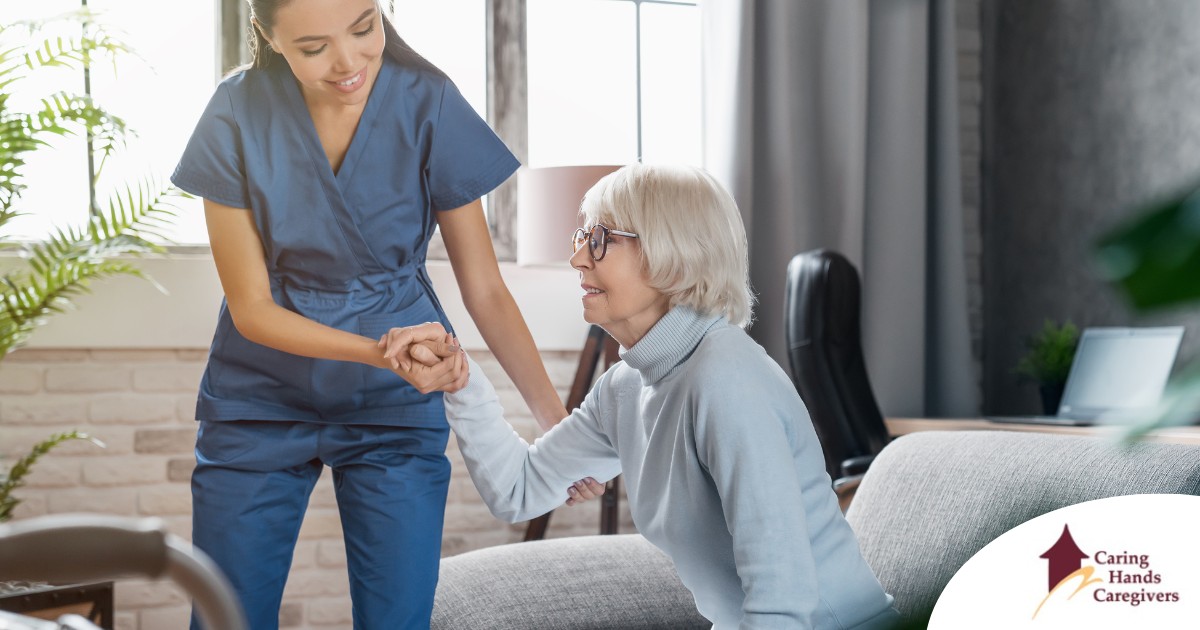 A caregiver demonstrates her caregiver skills by helping an older adult get up.