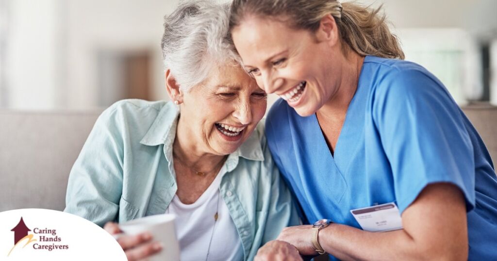 A woman in scrubs laughs with a senior woman, representing how caregiving can be a great career choice.